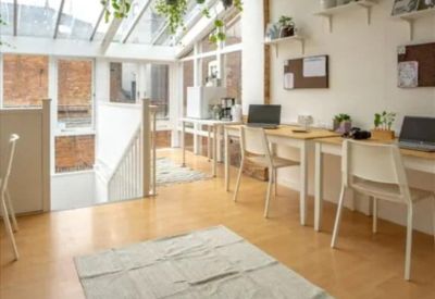 Bright corner office with floor-to-ceiling windows and city views.