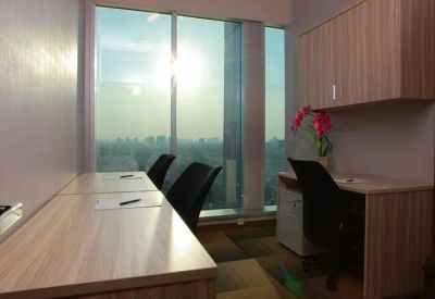 Private office with two desks and a large window overlooking the city at sunset.