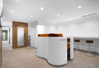 Curved white coworking pod in a bright breakout space with bar seating.