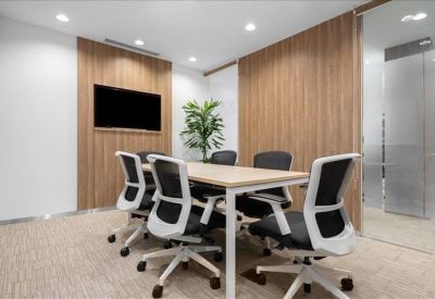 Professional meeting room featuring a light wood table, black chairs, and wood-paneled walls.