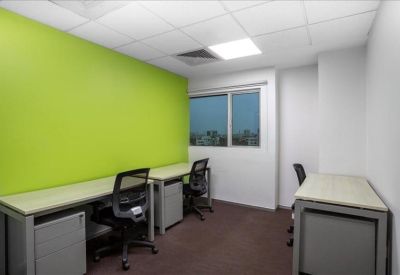 Private three-person office suite featuring a bright lime green accent wall and modern desks.