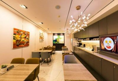 Dining area with wood-finish tables, contemporary lighting, and a digital menu board.