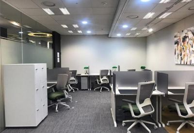 Open-plan workspace with grey partitions, ergonomic chairs, and modern overhead lighting.