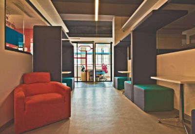 Hallway featuring a red armchair and individual privacy pods.