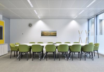 Spacious boardroom at Greko Creative Hub with lime green chairs and a long white conference table.