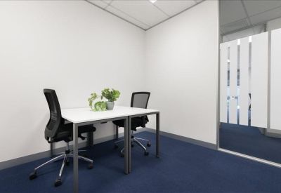 Private two-person office suite with white desks and green plants.