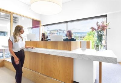 Contemporary reception desk with a white marble countertop and warm timber paneling.