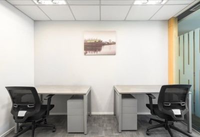 Private two-person office suite with grey desks and black mesh chairs.