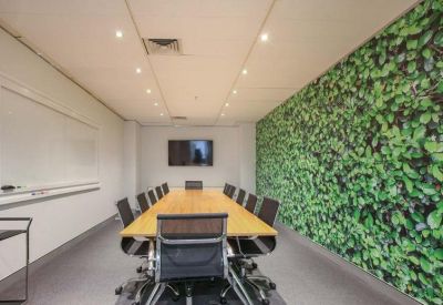 Professional meeting room featuring a long timber table and a green living wall.