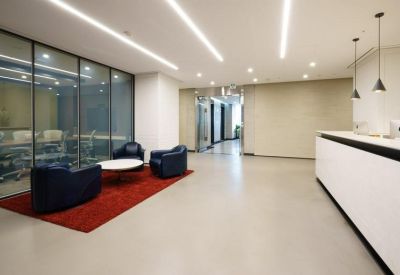 Reception area featuring a minimalist white desk and a red rug.