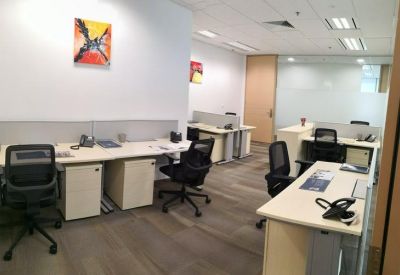 Bright office space featuring multiple workstations and colorful abstract wall art.