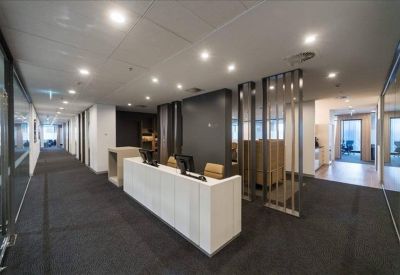 Professional reception desk area with warm lighting and decorative wooden partitions.