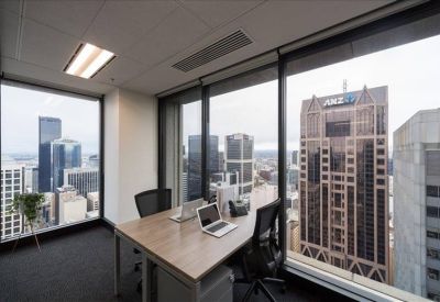 Private corner office with two desks and expansive floor-to-ceiling city views.