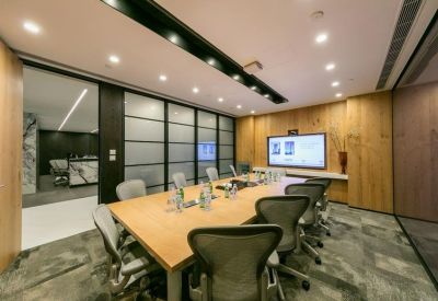 Professional meeting room with a large wooden table, ergonomic chairs, and wood-paneled walls.