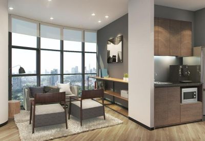 Bright communal lounge with grey armchairs and city views.