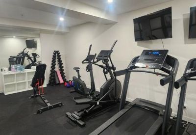 Well-equipped fitness center with treadmills, ellipticals, and weights.