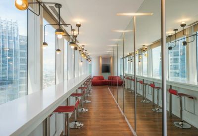 Window-side breakout bar with red stools and panoramic city views.