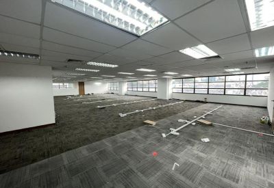 Expansive open workspace with carpet tiles and rows of windows.