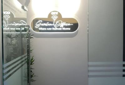 Branded glass entrance with glowing signage for Garden Office.