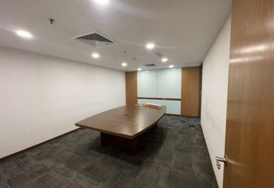Formal boardroom with a large central wooden conference table.