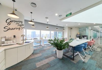 Bright communal break area with a curved counter, colorful chairs, and motivational wall art.