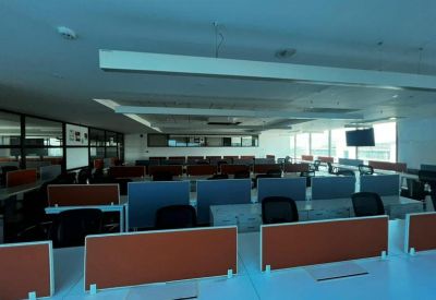 Expansive office with rows of desks and orange panels.