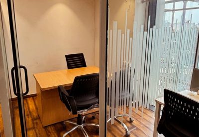 Compact private office suite with a wooden desk and warm ceiling lighting.