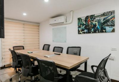 Professional meeting room with a wooden table and black mesh chairs.
