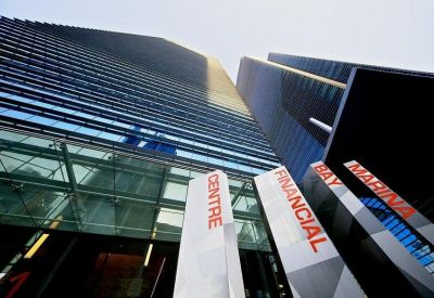 Ground level entrance with glass canopy and large building signage.