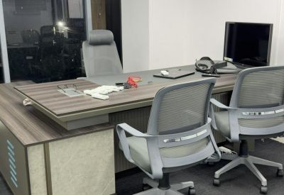 Executive private office suite with a large wooden desk and ergonomic mesh chairs.