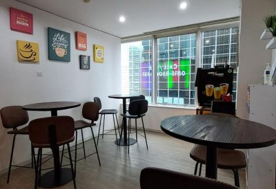 Communal break area with high tables, dark stools, and colorful wall art.