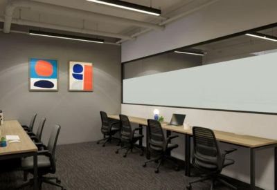 Shared workspace with long wooden desks and abstract wall art.