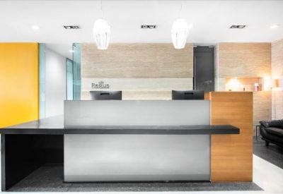 Professional reception desk with wood accents and overhead designer lighting.