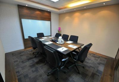Professional meeting room with a large dark table, ergonomic chairs, and whiteboard.