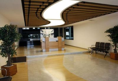 Reception lobby at Merkez Mah, Abide-i Hürriyet Caddesi with curved ceiling lights and wooden slat details.