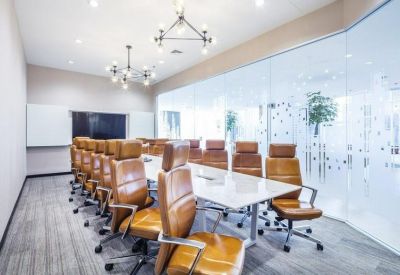 Large boardroom featuring tan leather chairs and contemporary chandelier lighting.