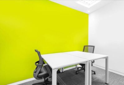 Private office featuring a vibrant lime green accent wall and two workstations.