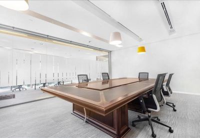 Professional boardroom with a large wooden table and grey ergonomic chairs.