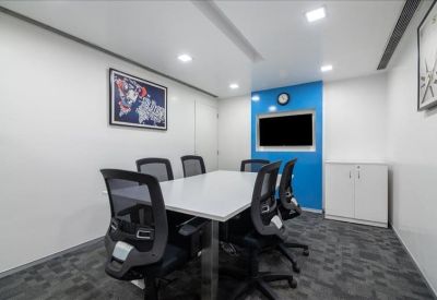 Modern meeting room with a white table and a blue accent wall with an integrated screen.