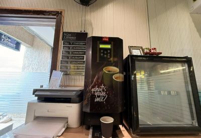 Self-service coffee station with a printer and small beverage refrigerator.