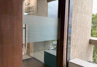 Entrance to the coworking space with a glass door and white cabinet storage.