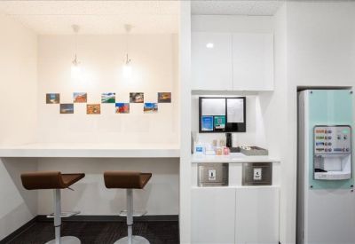 Communal breakout area with bar stools, water dispenser, and wall decor.