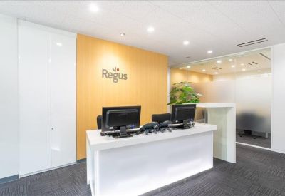 Reception area with a white front desk against a warm yellow feature wall.