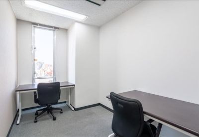 Private office suite with two desks and natural light from a window.