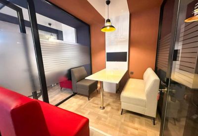 Modern booth seating area with a small table and warm pendant lighting.