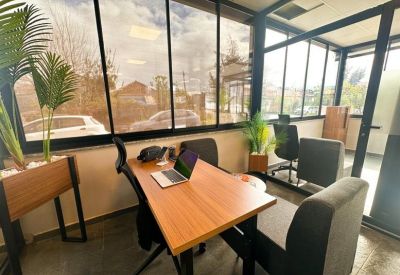 Bright glass-walled meeting room with a wooden table and outdoor views.
