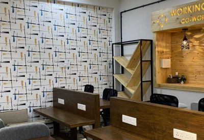 Open-plan workspace featuring patterned wallpaper and wooden partition desks.