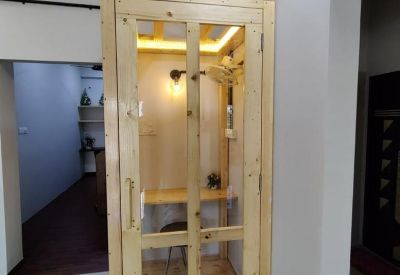 Small wooden telephone booth with a glass door for private calls.