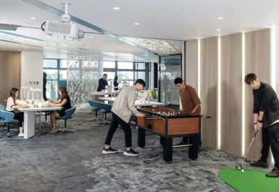 Spacious communal breakout area with foosball table, putting green, and lounge seating.