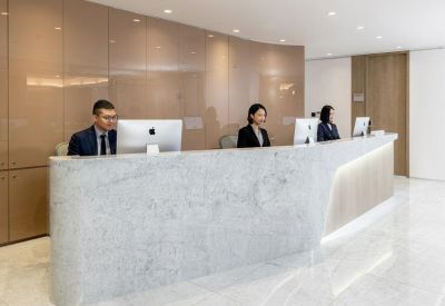 Bright reception area featuring a curved stone desk and professional staff.